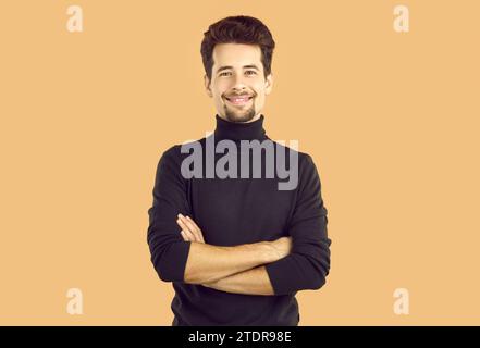 Portrait of confident young man crossing hands smiling at camera Stock Photo