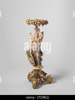 Gueridon in the form of angelic figure in draperie including volute -shaped tripod with wild boar heads, Anonymous, 1700 Gueridon of gilded polychromed lindenhout on a base with three legs in the form of volutes, with acanthus leaf and wild boar heads decorated. Above it is an angel in a draped robe, holding a shield and placed one above the head around leaf, decorated with stoned leaves and flowers. Coat of arms of Johan Boudaen (1634-1716). Coming from the Popkensburg house in Zeeland. NOTE: PENDANT BK-NM-3278 Low CountriesNetherlands wood (plant material). linden. gilding (material). paint Stock Photo