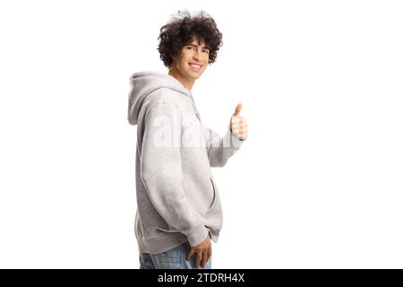 Guy with curly hair in a gray hoodie gesturing thumbs up isolated on white background Stock Photo
