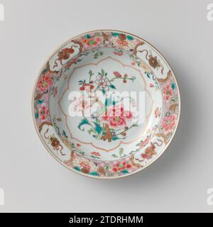 Soup plate with flowering plants, flower sprays and attributes of the Eight Immortals, anonymous, c. 1725 - c. 1749 Porcelain plate, painted on the glaze in blue, red, pink, green, yellow, black and gold. On the flat a scalloped cartouche with a group of flowering plants; Four groups on the wall with flowering plants (peony, aster); the edge with servetwork with large flowers interspersed with four times attributes of the eight immortals (Lotusstengel, gourd) in lobed cartouches; The rear with three times a mushroom (Lingzhi). A chip in the edge. Famle Rose. China porcelain. glaze. gold (metal Stock Photo