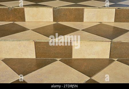 Concrete stairs are decorated with square, rectangular and triangular ceramic tiles Stock Photo