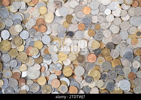 A heap of various money coins of different denominations from different countries. Currency exchange and finance concept. Lots of different coins. Stock Photo