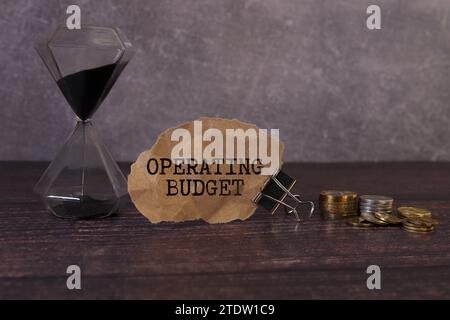 Closeup on businessman holding a card with text OPERATING BUDGET, business concept image with soft focus background and vintage tone Stock Photo