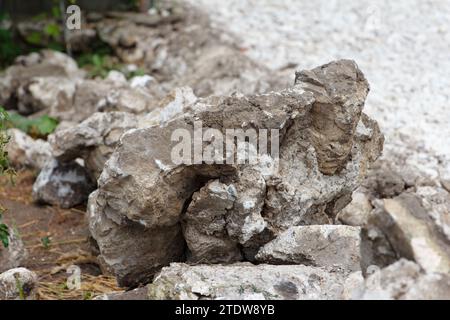 Construction, laying road on a new one. On side of the road lie blocks of large gray stones, background Stock Photo