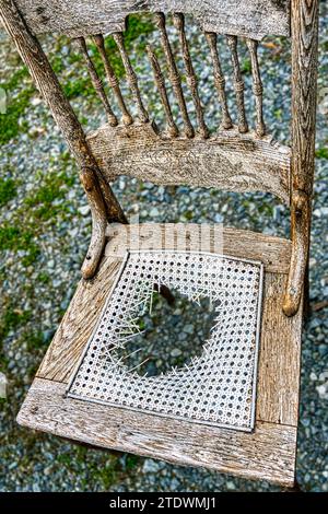 Old, damaged wicker bottom chair at a small roadside store dealing in antiques and vintage goods in Boone, North Carolina. Stock Photo