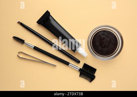Flat lay composition with eyebrow henna and tools on beige background Stock Photo
