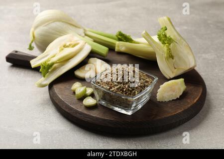 Fennel seeds in bowl and fresh vegetables on gray table Stock Photo