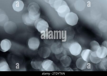 Defocused image of lights in black and white. Layered gray bokeh spots. High resolution abstract background with copy space. Stock Photo