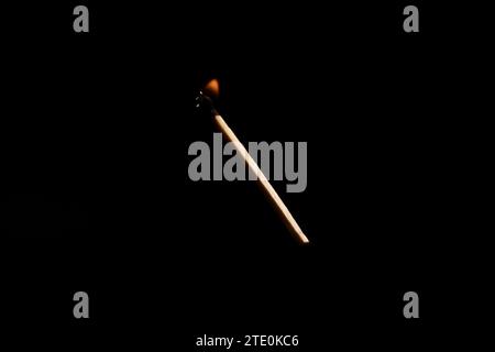 Lit and falling match on a black background. Stock Photo