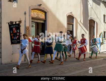 Orvieto, Italy - 18 November, 2023: marching band dressed in medieval clothes marching through the streets of old town Orvieto Stock Photo