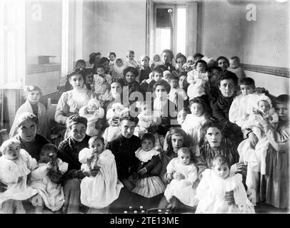 12/29/1911. In the relief house in the Palacio district. Women of the People, with their Children, in the distribution of Clothes that was made yesterday to those Assisted by the Charitable Institution Called La Gota de Leche. Credit: Album / Archivo ABC / Ramón Alba Stock Photo