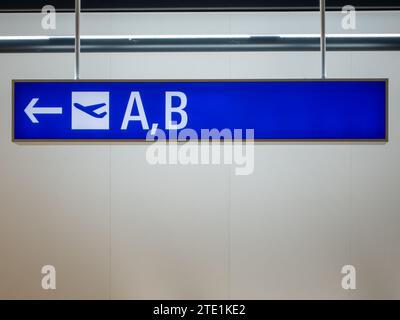 Frankfurt, Germany - June 7, 2023 - blue display with white directional arrow, to departure gate A and B with a pictogram for a starting plane Stock Photo