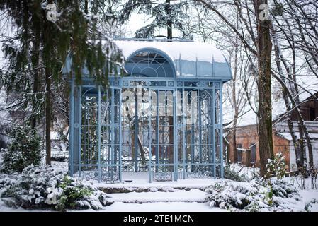 A Blue metal iron gazebo made of metal in a snow garden in winter  Stock Photo