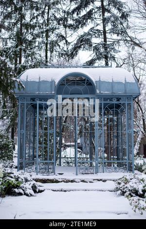 A Blue metal iron gazebo made of metal in a snow garden in winter  Stock Photo