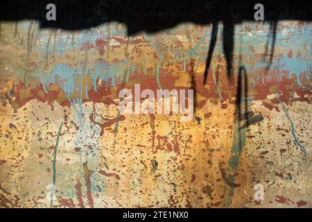 Old, weathered, rusting, metal surface with random, multicolored cracked and peeling paint layers. Stock Photo