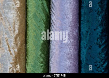 Abstract detail of giant spools of gold, green, purple, lavendar and blue, soft felt fabrics. Stock Photo