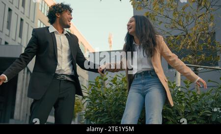 Indian businessman Arabian businesswoman business partners colleagues people coworkers in city downtown happy smiling laughing enjoy having fun laugh Stock Photo