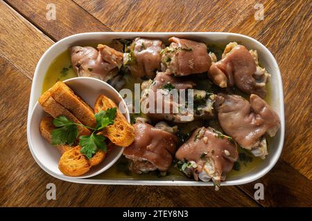 Authentic Portuguese Alentejo Pig Trotters with Coriander Sauce, a traditional delicacy capturing the essence of Portuguese cuisine. Stock Photo