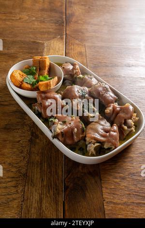 Authentic Portuguese Alentejo Pig Trotters with Coriander Sauce, a traditional delicacy capturing the essence of Portuguese cuisine. Stock Photo