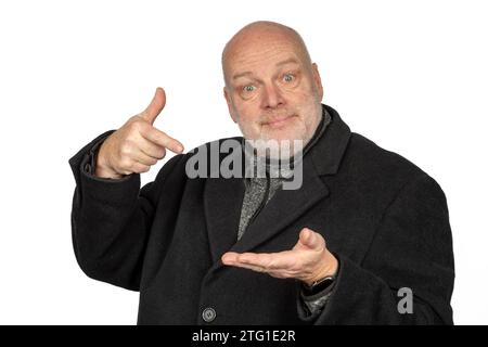 Happy 58-Year-Old Man in Winter Coat Looking in Camera and Holding Something Stock Photo