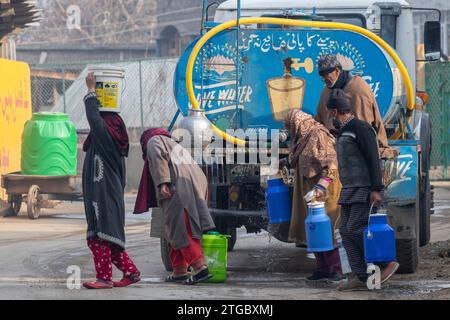 Kashmiri residents collect drinking water from a water truck on a cold winter day in the outskirts of Srinagar. (Photo by Faisal Bashir / SOPA Images/Sipa USA) Stock Photo