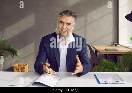Smiling businessman entrepreneur in suit talking to camera Stock Photo