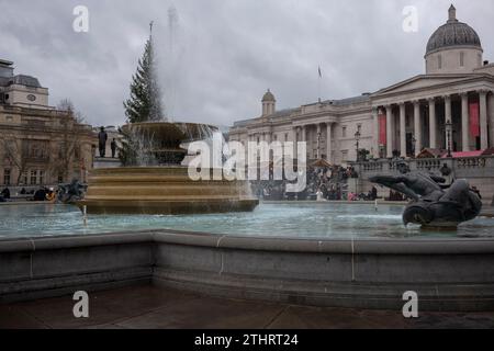 Festive tourists out in force taking selfies and pics of each other in front of the fountains on Trafalgar Square in London's West End, 20th Dec 2023 Stock Photo