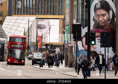 Christmas shoppers and digital advertising at Tottenham Court Road ,on 20th December 2023, in London, England. Stock Photo