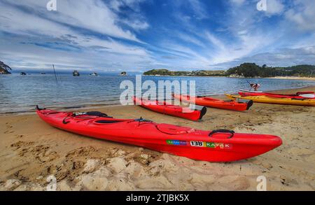 Kayaks on the beach, Kaiteriteri, New Zealand. Kaiteriteri is a small coastal town and seaside resort in the Tasman Region of the South Island of New Zealand. It is close to Abel Tasman National Park. Kaiteriteri relies on tourism for much of its income.  It is also a hub for the adventure tourism throughout the area.   Credit: BSpragg Stock Photo