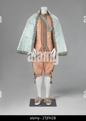 Maskerade costume, consisting of Wambuis and knee pants made of salmon pink silk daum mast with large flower, fruit and leaf motifs in addition to grid fillings, with corresponding cape of light blue rips side and accessories, anonymous, c. 1740 - c. 1770 Costume in 17th century style, salmon pink suit and a light blue cloak. As a 'Van-Dyck costume' or a musketier suit. Bets from Wambuis (A), Kniebroek (B), Mantel (C), Bandelier (D), Garter Bands (E), Shoe Stretches (F), Rosette Bow (G). Bright salmon pink silk daum mast with large flour/fruit/leaf motif with some grid fillings, linen lining. Stock Photo