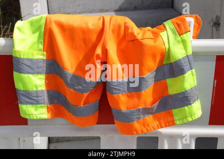 Short work trousers hang over a warning barrier to dry Stock Photo
