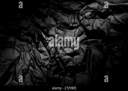 Texture of crumpled black paper with gradient. Dark paper background with wrinkles and folds Stock Photo