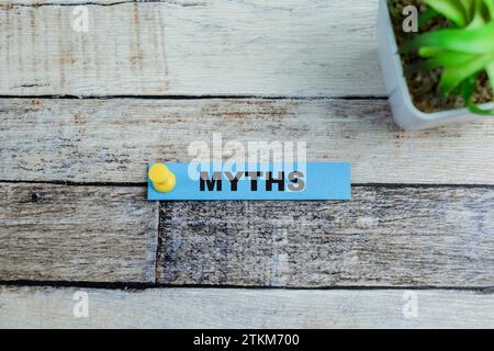 Concept of MYTHS write on sticky notes isolated on Wooden Table. Stock Photo