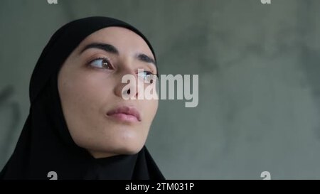 Close-up of a representative of the fair sex, a Muslim woman looking at the  camera. She looks modest and frequent. Cruel rules in relation to women in  Islam, the obligatory wearing of the hijab