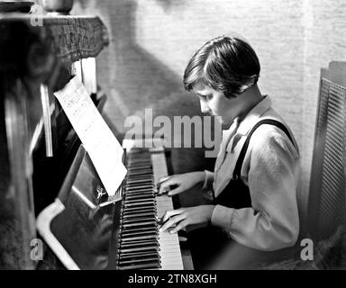 A young girl playing a piano ca. 1932 Stock Photo