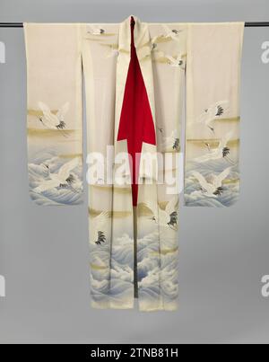 Set of three women’s kimonos decorated with cranes, 1920 - 1940 The lower (shitagi) of a set of three formal kimono with long sleeves for an unmarried young woman (Furisode), with a decoration of crane birds above a rough sea on the sleeves, front and back. White crepe silk (surgery) with yuzen decoration in white, black and blue, the cranes with embroidered detailing, cloud tires in gold foil and the waves with detailing in silver wire and white paint. Red silk lining. Five family weapons (Mon) van Anjelieren (Nadeshiko) in gold foil. Japan silk painting / embroidering The lower (shitagi) of Stock Photo
