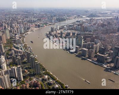 SHANGHAI, CHINA - APRIL 13, 2023: Giant skyscrapers in Pudong, Shanghai with Huangpu river and nautical transportation Stock Photo