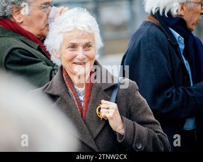 Strasbourg, France - Mar 29, 2023: Elegant Confident senior woman with defocused background pf other seniros peacefully protest in front of the Europe Stock Photo