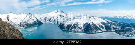 Hiker gazes at the stunning Garibaldi Lake from Panorama Ridge. Stock Photo