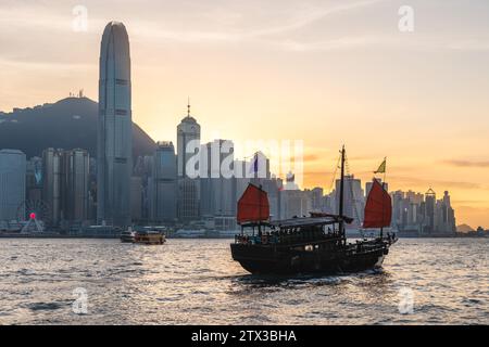 A Chinese Junk operating at victoria harbor in hong kong, China Stock Photo