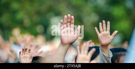 Many hands raised in the crowd of people Stock Photo