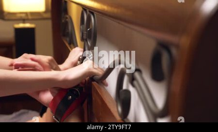 BDSM, sex toys. romantic couple in bed. the hands are handcuffed to the  wrought headboard. close-up, details