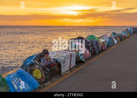 Large painted rocks along a breakwater at sunrise at Port Macquarie on the North Coast of New South Sales, Australia. Stock Photo