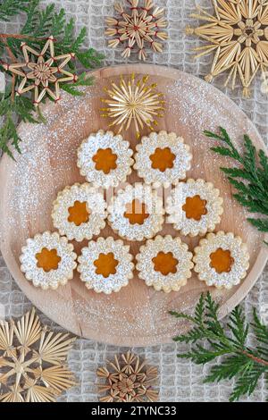 christmas biscuits Spitzbuben with apricot jam on wooden board Stock Photo
