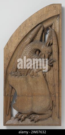 Panels from an organ case in the church of Saint Vitus in Naarden, Jan van Schayck, c. 1510 - c. 1520 A sitting, to the left desired griffin with the curved long neck and head to the right. He holds the shield with both claws, above which his tail protrudes; The half -spread wings fill the background. The hatch has the shape of half a pointed arch and has a holly list that encloses Maaswerk. Utrecht oak (wood)   Big of St. Vitus Church A sitting, to the left desired griffin with the curved long neck and head to the right. He holds the shield with both claws, above which his tail protrudes; The Stock Photo