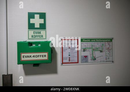a green evacuation case hangs on the wall next to an escape plan Stock Photo