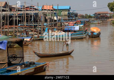 Boy on small boat moving along the waterways, Floating village Kampong Phluk in Tonle Sap Lake, Cambodia, Asia. Stock Photo