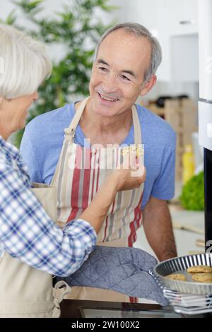 baker holding a tray with freshly baked cookies Stock Photo