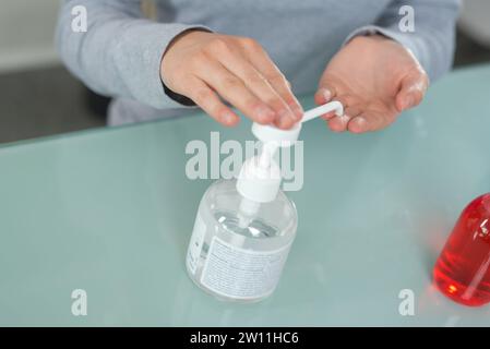 female using hand press with alcohol-based sanitizer on hands Stock Photo