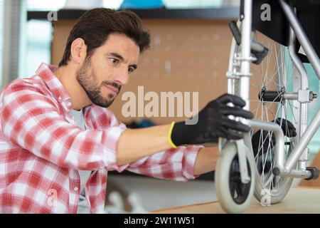 disabled man repairing a chair in his workplace Stock Photo